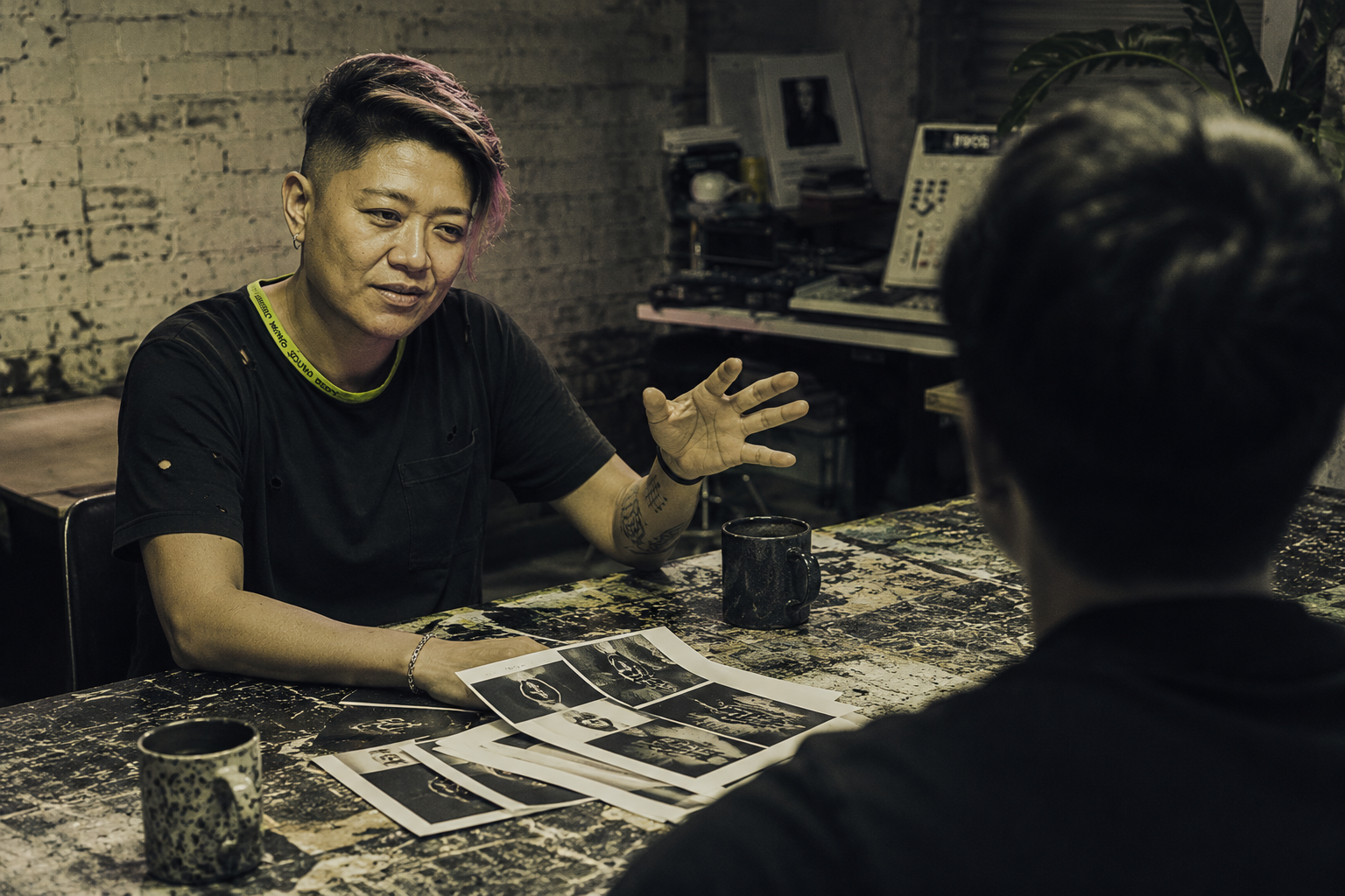 Lani gesturing across work table with client, mood boards and coffee, Marrickville interior
