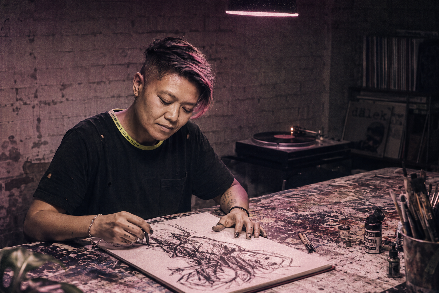 Lani at drafting table, ink-stained hands, mid-sketch with charcoal, vintage record on turntable, mauve gel light